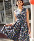 Woman wearing vintage-inspired chicken print cotton dress with pockets and retro-inspired styling.