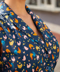 Close-up of the notched collar and button-front detail on a navy blue cotton dress.