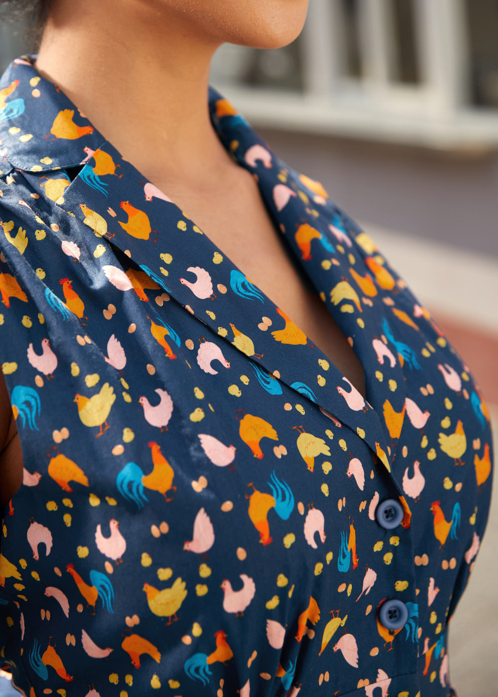 Close-up of the notched collar and button-front detail on a navy blue cotton dress.