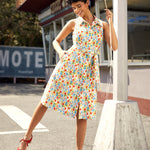 Vintage-inspired sleeveless midi dress with button-front, removable tie belt, and novelty vegetable print.
