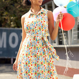Woman styling a retro cotton shirt dress with colorful produce print for a sunny summer outing.