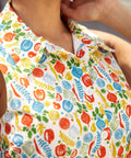 Close-up of the colorful vegetable print on a cotton shirt dress with pointed collar and button-front bodice.