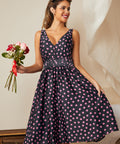 Model wearing navy fit and flare midi dress with pink confetti dot print