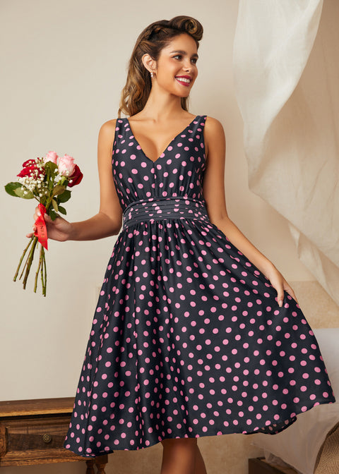 Model wearing navy fit and flare midi dress with pink confetti dot print