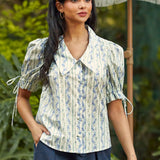 Woman wearing the Dear Diary Blouse in Blue Willow, a vintage-inspired cotton blouse with an oversized pointed collar and covered buttons.