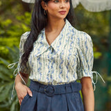 Vintage-inspired women's cotton blouse featuring a statement collar, covered button front, and romantic puff sleeves.
