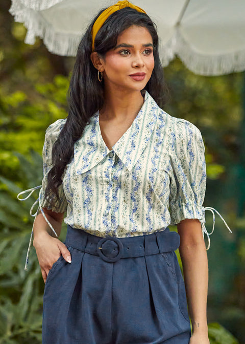 Vintage-inspired women's cotton blouse featuring a statement collar, covered button front, and romantic puff sleeves.