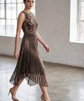 Woman wearing a metallic dress in a room with large windows and white brick walls.