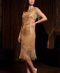 Woman wearing a gold sequin dress with fringe in a dimly lit room.