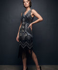 Woman wearing a black and silver beaded flapper dress against a dark background