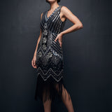 Woman wearing a black and silver beaded flapper dress against a dark background