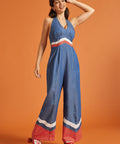 Woman roller skating in a retro-inspired wide-leg halter jumpsuit with bold color-block accents.
