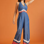 Woman roller skating in a retro-inspired wide-leg halter jumpsuit with bold color-block accents.
