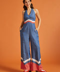 Woman posing in a vintage-inspired wide-leg jumpsuit with side pockets and chevron trim.