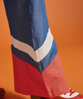 Close-up of the contrast chevron hem on a wide-leg blue jumpsuit.