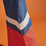 Close-up of the contrast chevron hem on a wide-leg blue jumpsuit.
