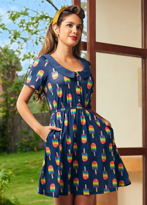 Woman wearing a navy dress with colorful popsicle pattern outdoors.