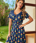 Model wearing navy dress with rainbow popsicle print and Peter Pan collar, front view