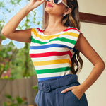 Woman wearing a colorful striped shirt and blue pants outdoors.