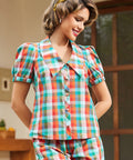 Model wearing multicolor retro check blouse with oversized collar and puff sleeves, front view