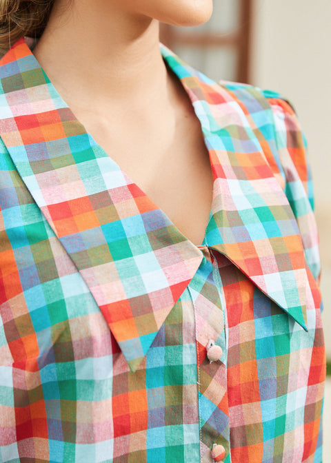 Close-up of oversized collar and button-front detail in retro check pattern