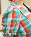 Detail of puff sleeve with elastic cuff in multicolor check fabric