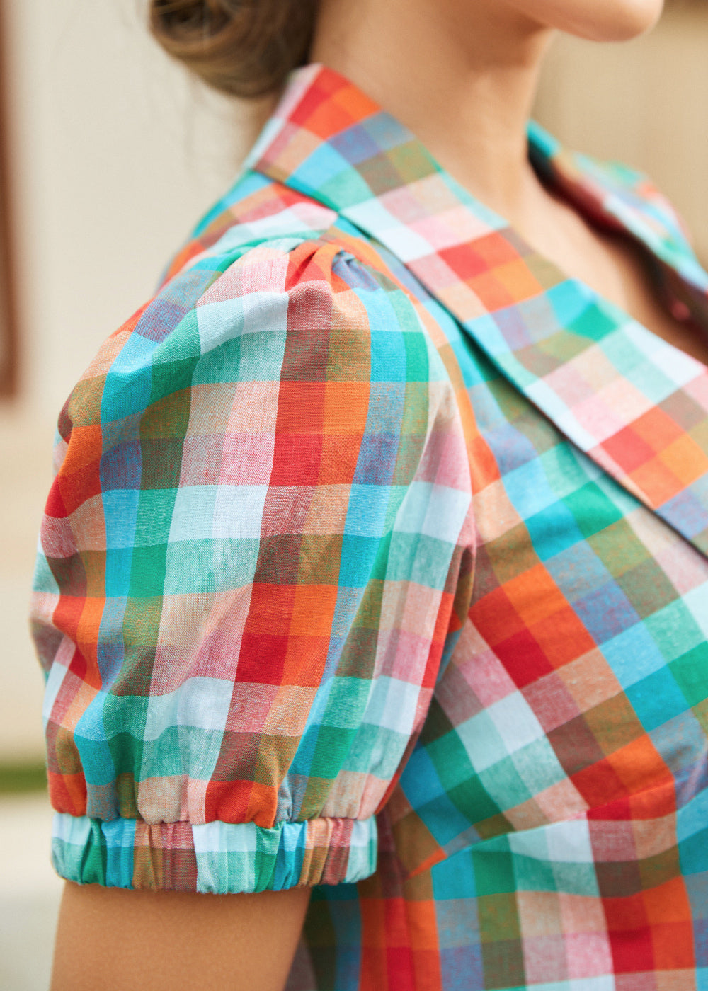 Detail of puff sleeve with elastic cuff in multicolor check fabric