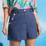 Front view of linen-cotton sailor shorts with decorative side buttons and front pockets.