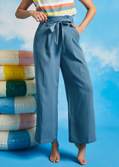 Woman posing in dusty blue vintage-inspired cropped wide leg pants with sash belt and side pockets