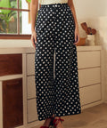 Person wearing black polka dot pants in a kitchen setting