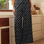 Person wearing black polka dot pants in a kitchen setting