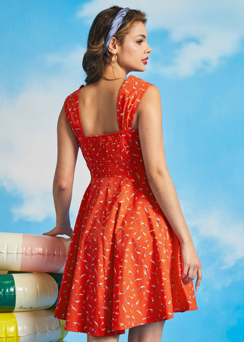 Back view of orange sleeveless sundress with smocked back panel and novelty swim print
