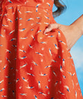 Close-up of orange cotton sundress with synchronized swimmer print and pockets