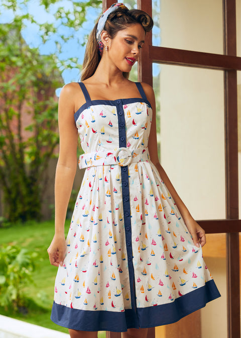 Woman wearing a white dress with colorful sailboat pattern in a vintage style