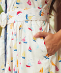 Woman showing side seam pocket on full skirt dress with sail boat print