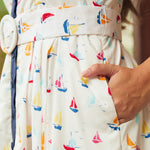 Woman showing side seam pocket on full skirt dress with sail boat print