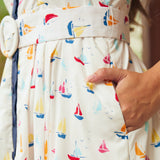 Woman showing side seam pocket on full skirt dress with sail boat print