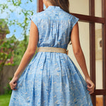 Back view of blue seaside print dress showing gathered waist and full skirt