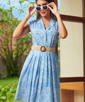 Woman wearing a ModCloth Breezy Boardwalk Shirt Dress with sunglasses, styled for a vintage coastal look