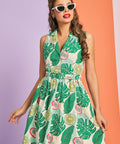 Woman wearing vintage-inspired citrus and palm leaf print cotton dress with belt