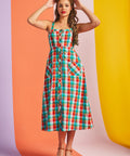 Woman wearing colorful rainbow plaid midi dress with button front and pockets