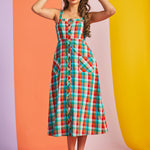 Woman wearing colorful rainbow plaid midi dress with button front and pockets