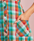 Close-up of rainbow plaid patch pocket and button-front detail on midi dress
