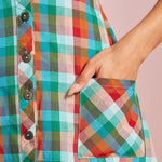 Close-up of rainbow plaid patch pocket and button-front detail on midi dress