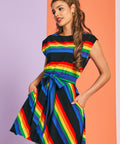 Woman wearing colorful rainbow stripe dress with removable sash belt and pockets