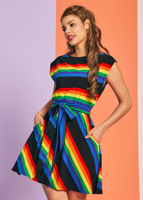 Woman wearing colorful rainbow stripe dress with removable sash belt and pockets
