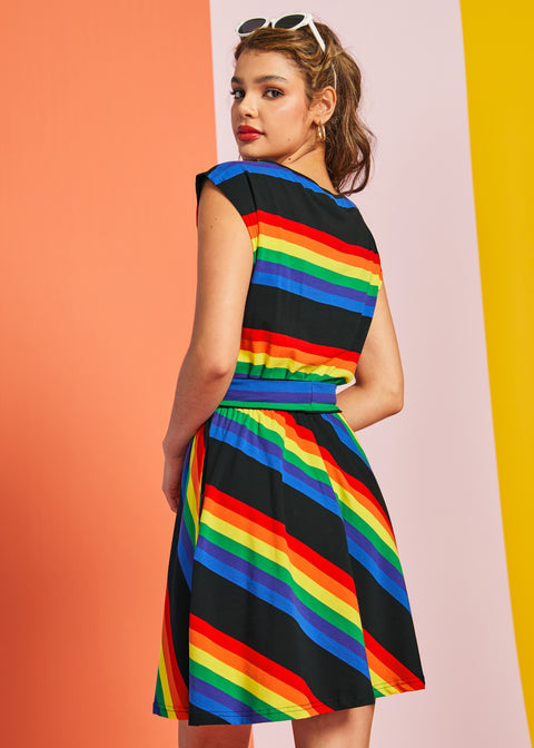 Back angled view of rainbow striped fit and flare dress with cap sleeves and waist seam detail