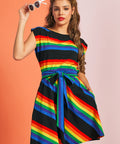 Woman wearing rainbow stripe fit and flare dress with boatneck neckline and sash tie waist