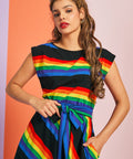 Woman wearing colorful rainbow stripe fit and flare dress with side pockets and boatneck neckline