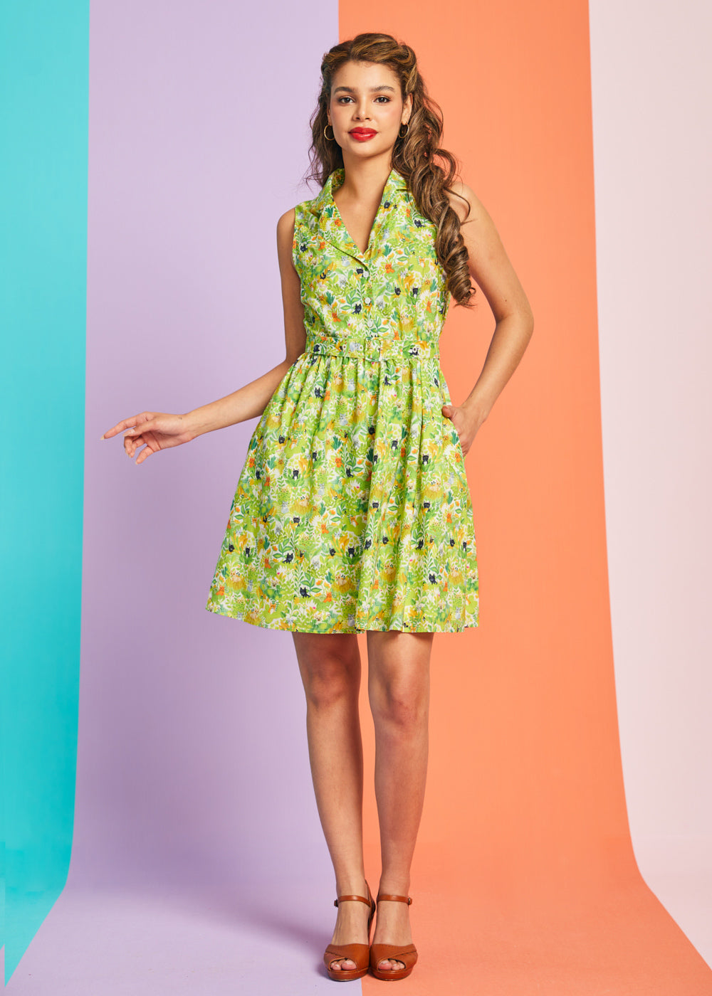 Woman modeling vintage-inspired cat print dress with button-front bodice and matching belt